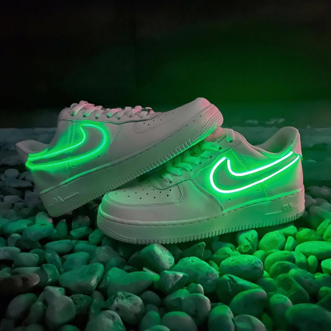 Customized Air Force 1 Sneakers with Neon Lights glowing green on rocks.